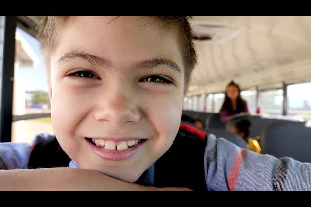 Young boy smiling on a school bus