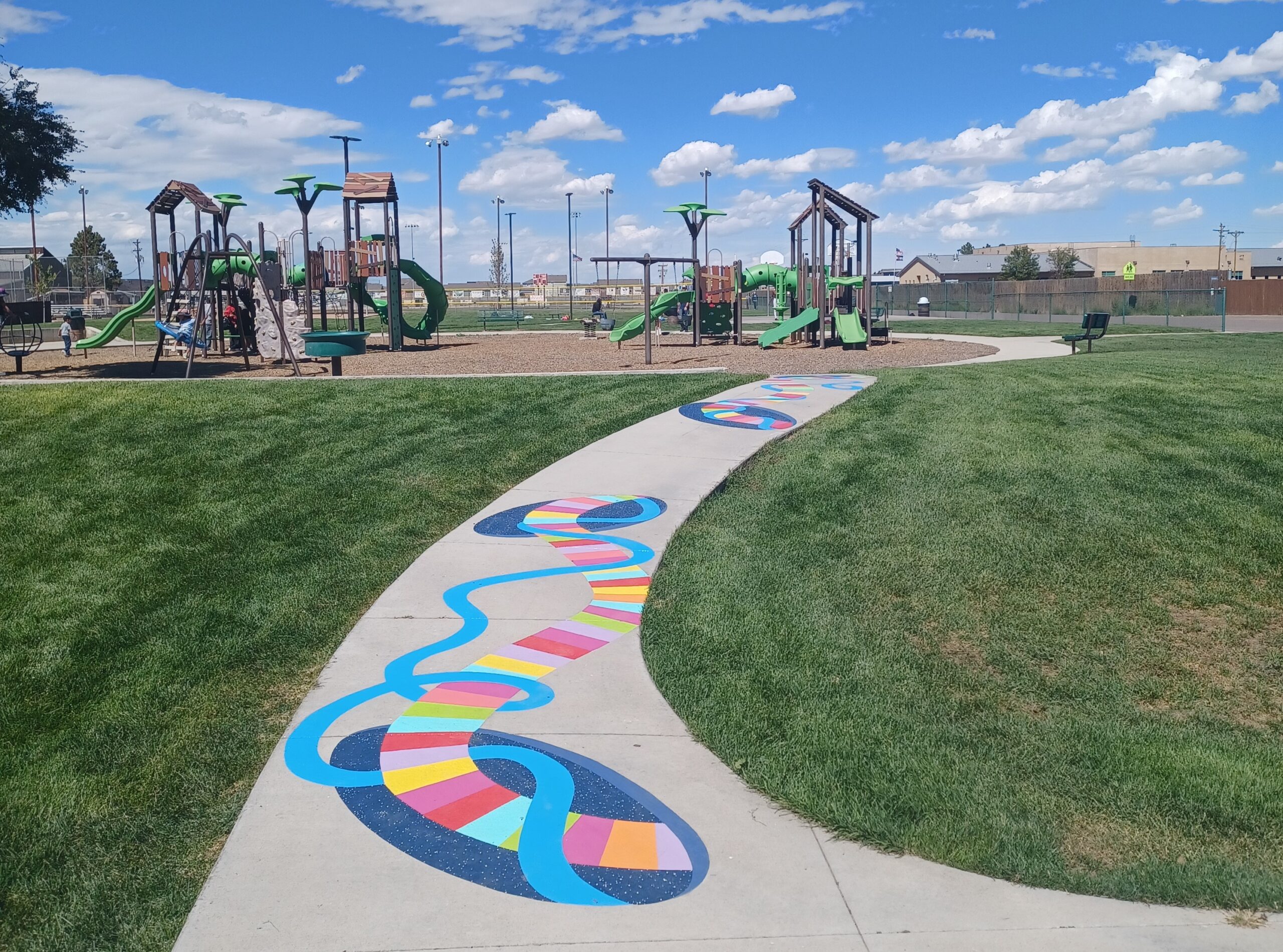 Colorful path leads to playground with slides and climbing structures