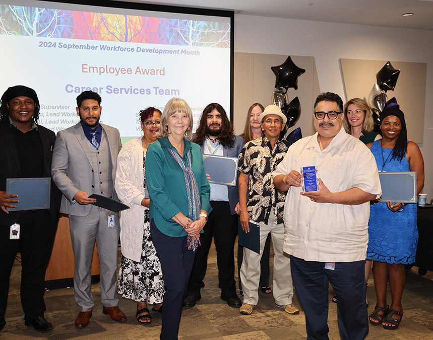 Career Services Team receiving Employee Award during 2024 September Workforce Development Month event, with group holding plaques.