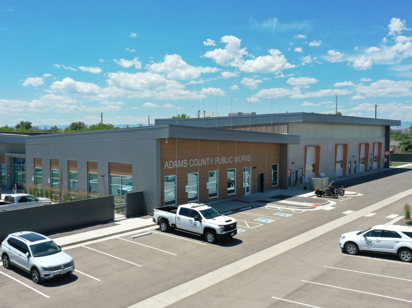 Adams County Public Works building with parked cars and blue sky above