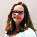 Amie smiling, wearing glasses and a light blue top