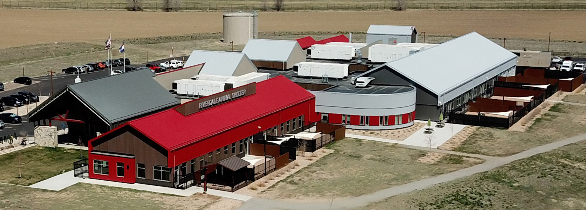 Pikes Peak Regional Shelter with red roof, parking lot, and outdoor enclosures visible.