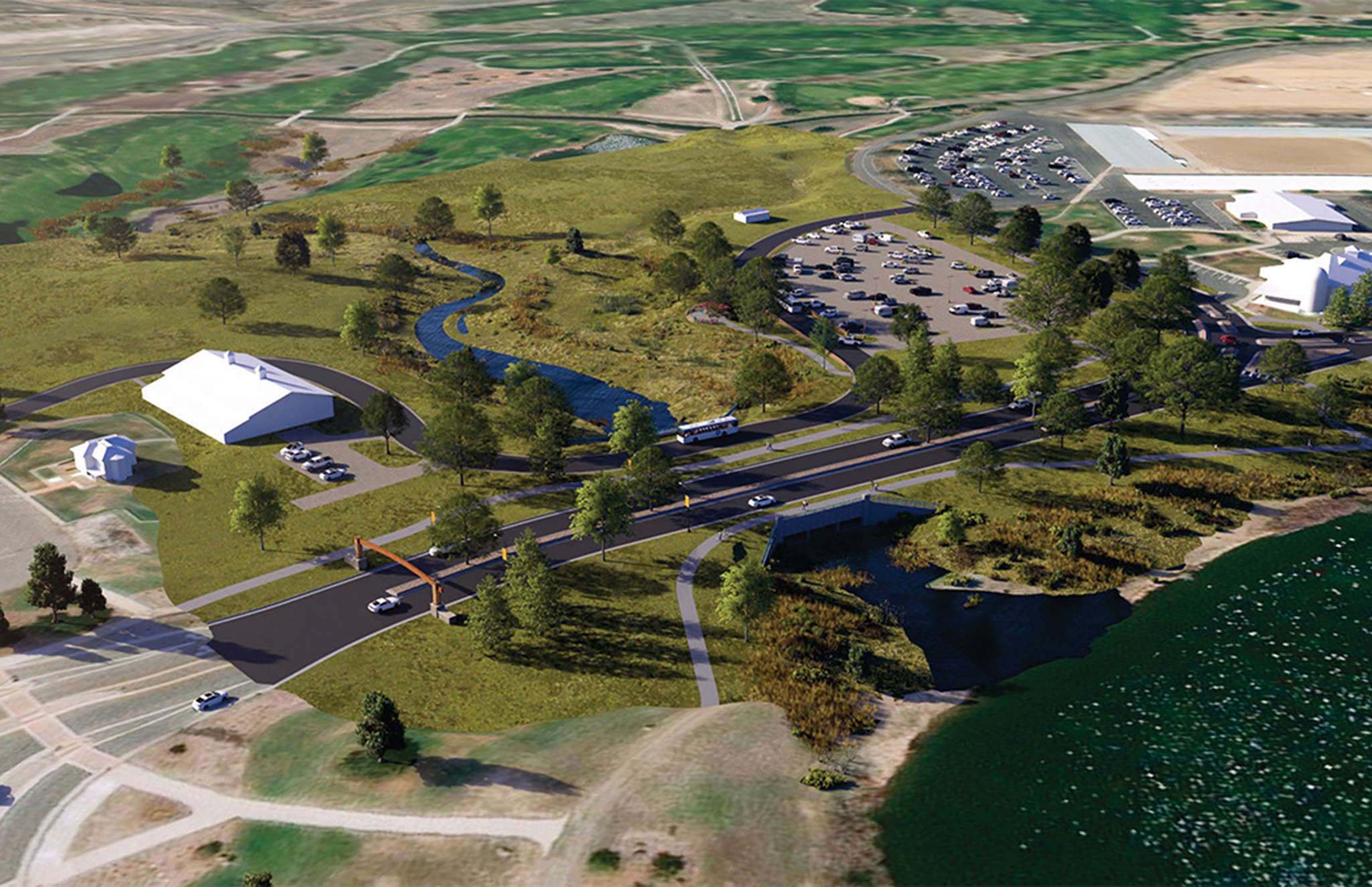 Aerial view of a scenic park with parking lots, winding roads, grassy areas, and a river.
