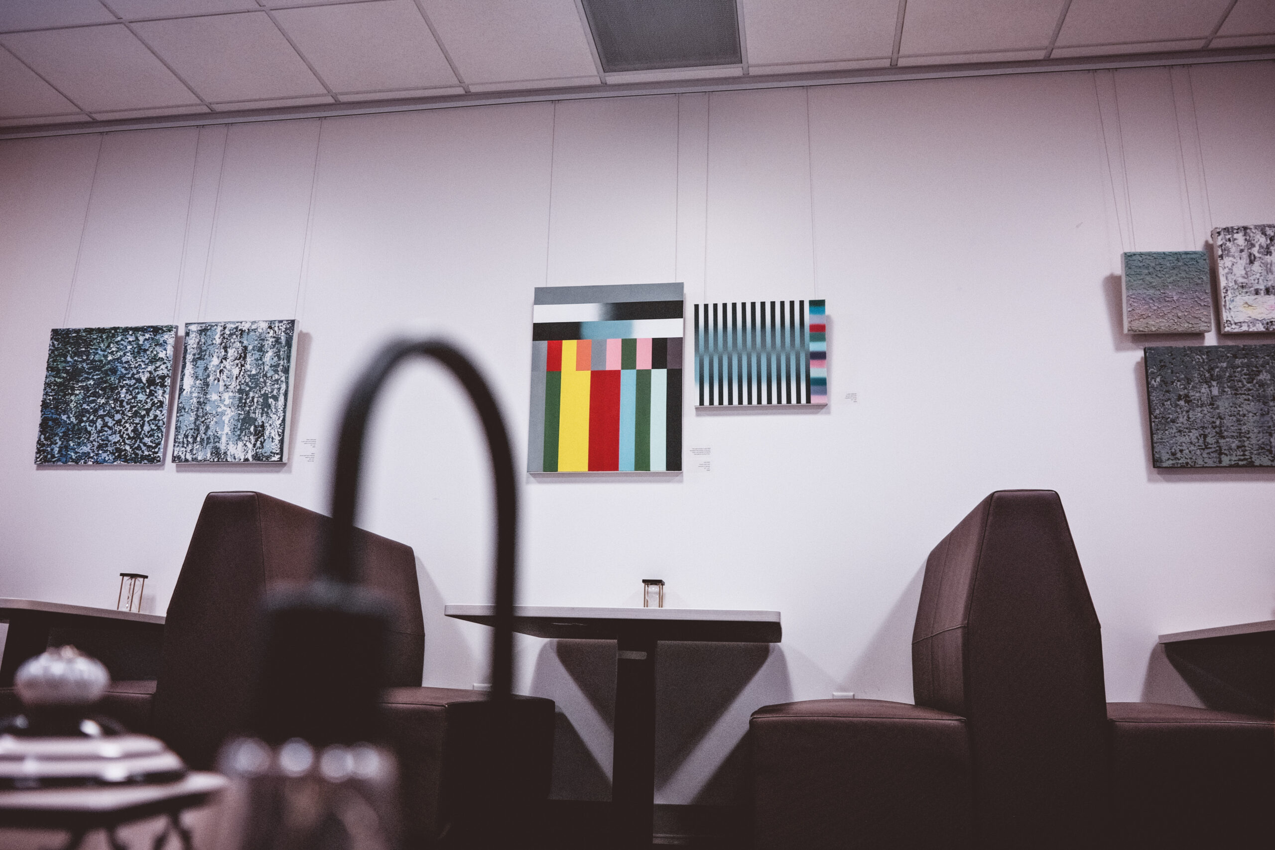 Booth seating area with abstract art on a gallery wall