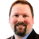 Chase-Evans.jpg smiling man in business attire with beard and mustache