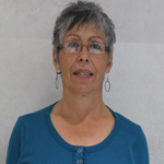 Christina smiling in glasses and blue shirt against a light background