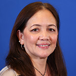 Emily-Alba is smiling against a blue background.