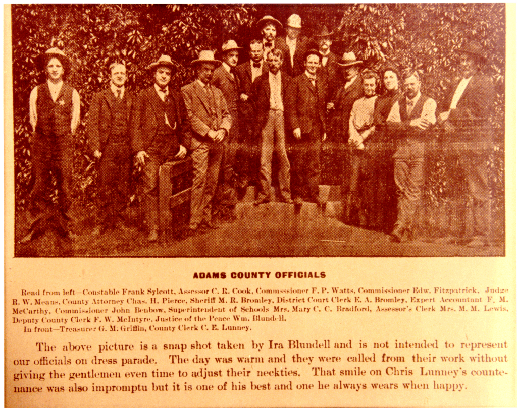 Adams County officials group photo with text describing the image context and individuals' roles.