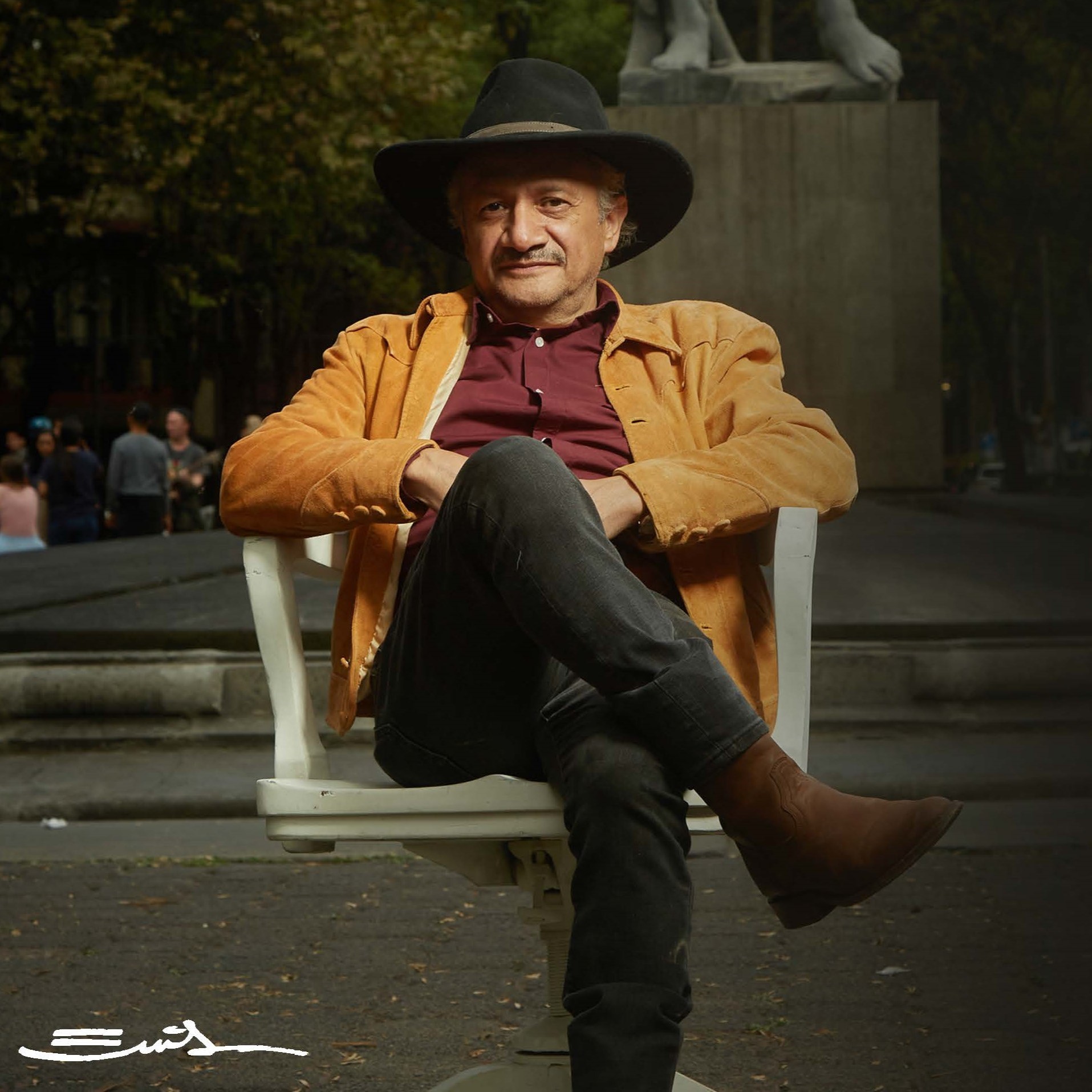 Folklorico-Espectacular, seated man in a black hat with a confident expression