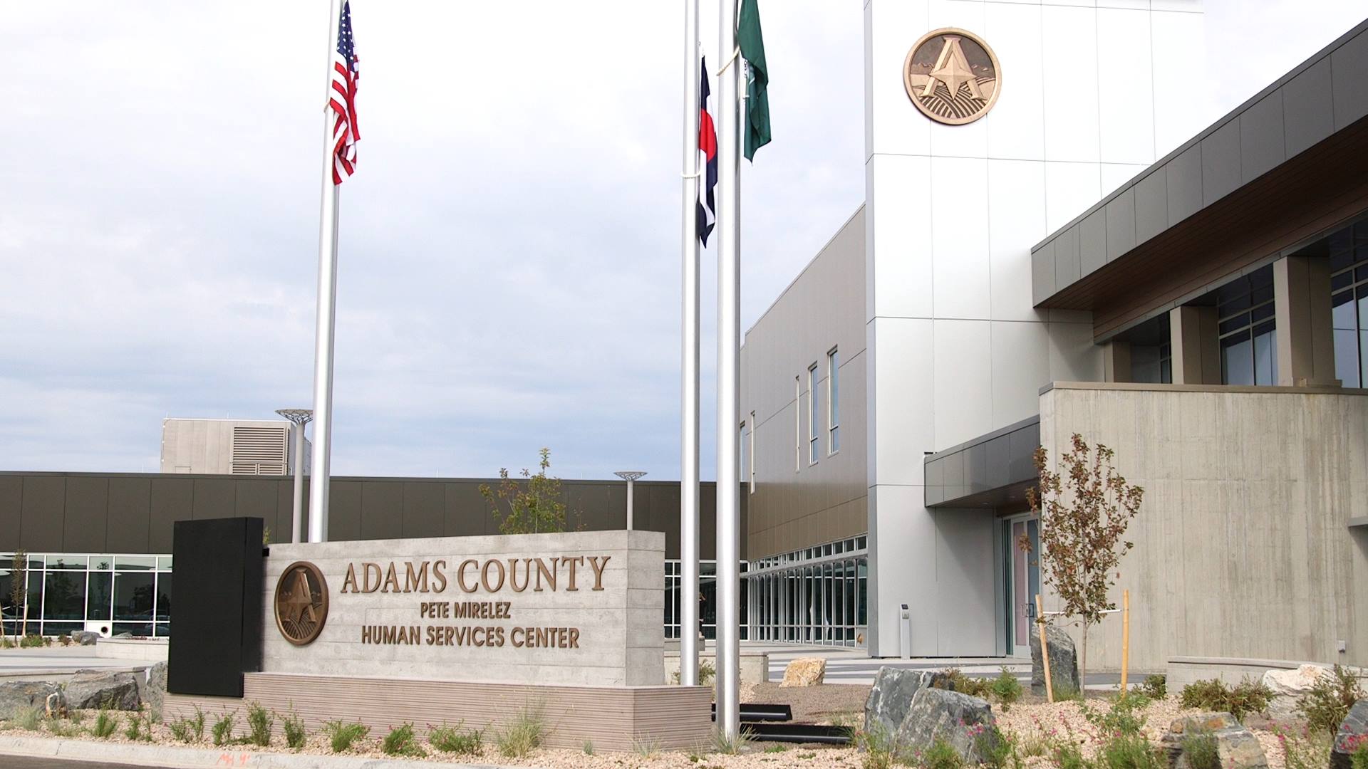 Adams County Pete Mirelez Human Services Center entrance with three flags.
