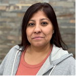 Lusina Hernandez wearing a gray hoodie, smiling gently, with a neutral background