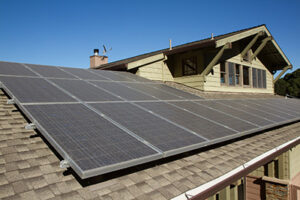 Solar panels covering a residential rooftop under a clear blue sky