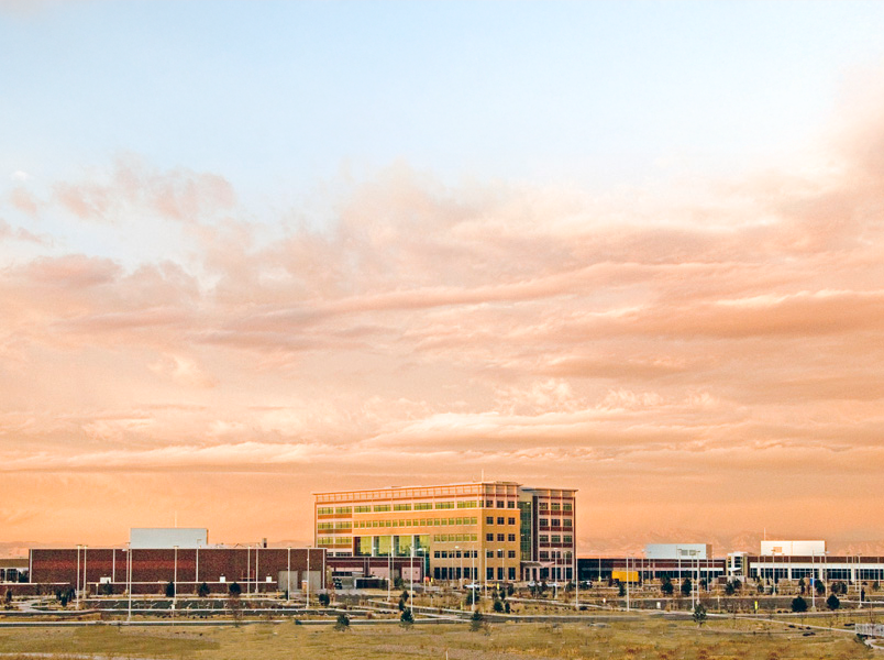 Adams County Government center building with modern architecture at sunset under a colorful sky