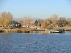 Lakeside park with gazebo and pier, surrounded by autumn trees.