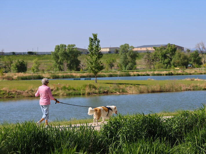 Woman walking dog in Twin Lakes Park