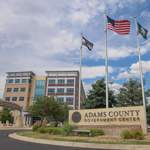 Adams County Government Center entrance with flagpoles and modern building in background