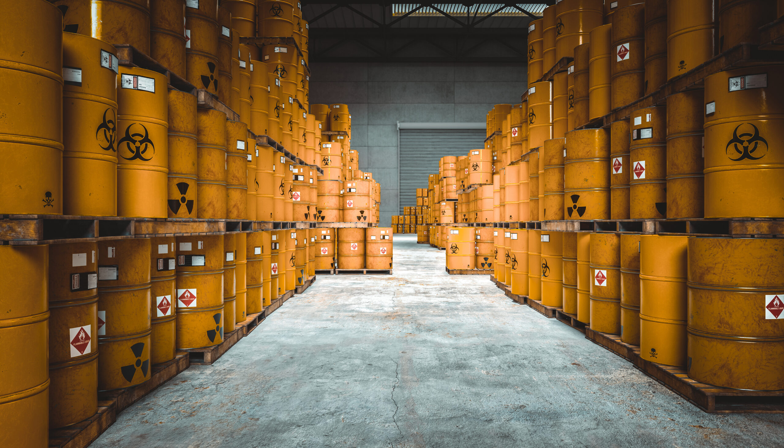 Barrels labeled with radioactive and biohazard symbols stacked in a warehouse.