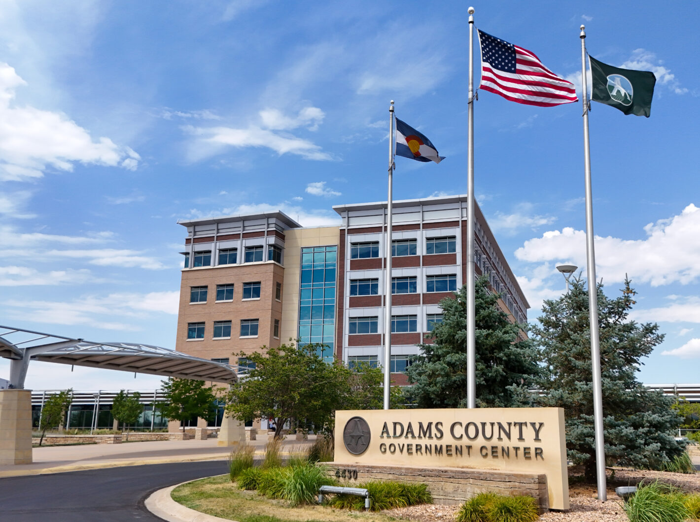 Adams County Government Center with flags and a modern building