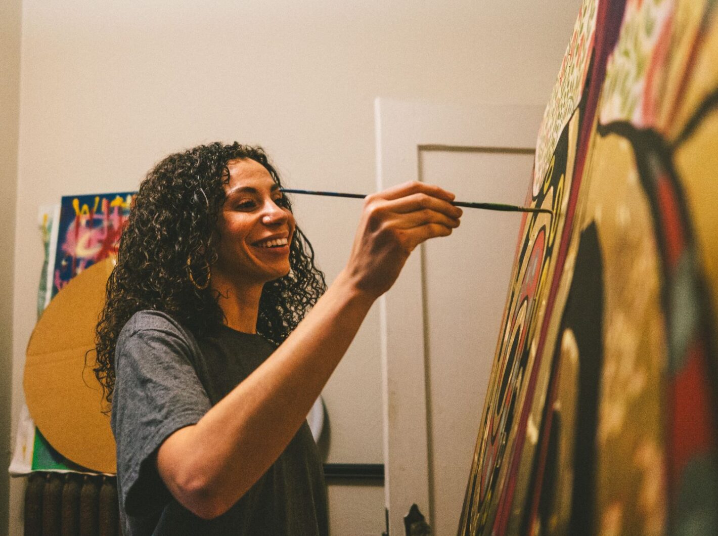 CM8X9596 painting vibrant canvas with a smile, showing creativity and joy