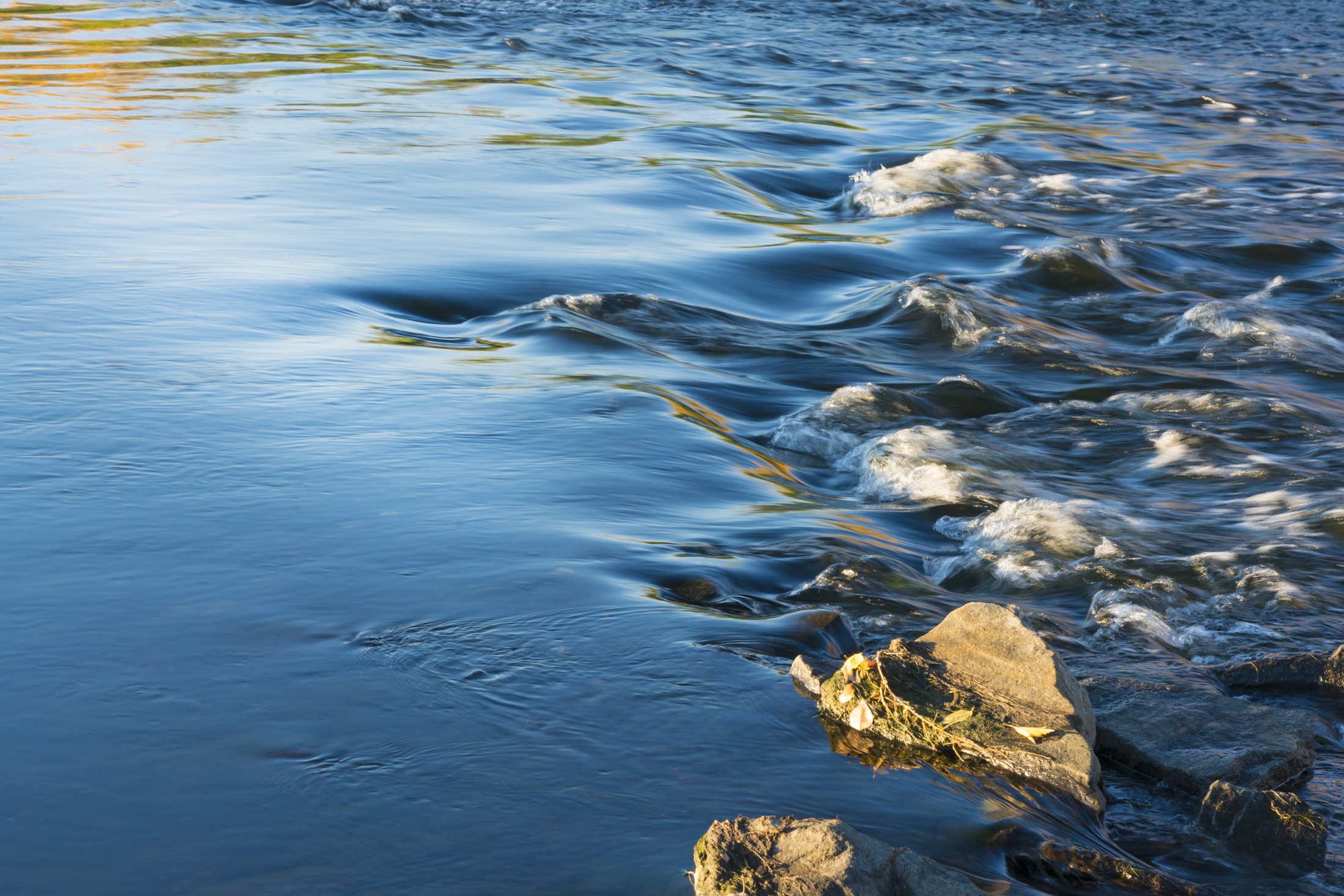 Flowing river water with rocks in the foreground