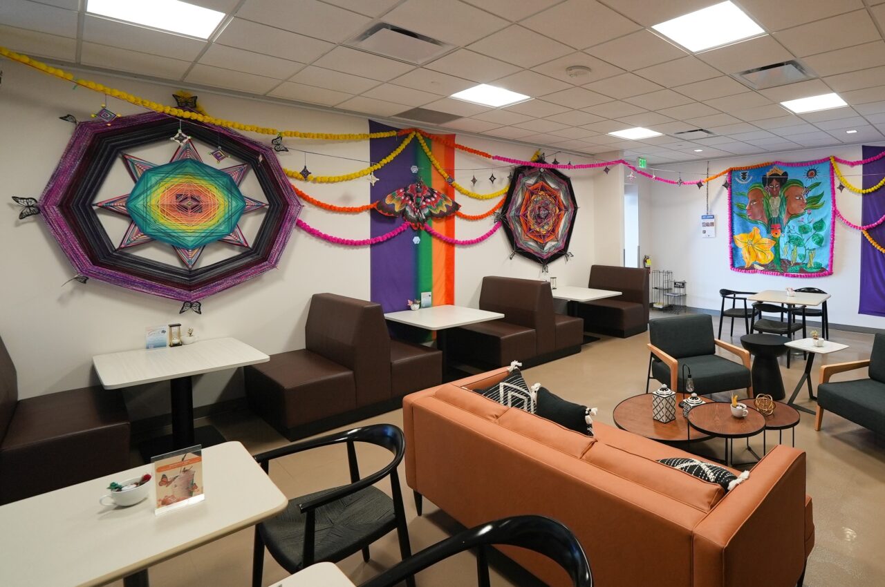Colorful, cozy café with vibrant geometric wall art and comfortable seating arrangements.